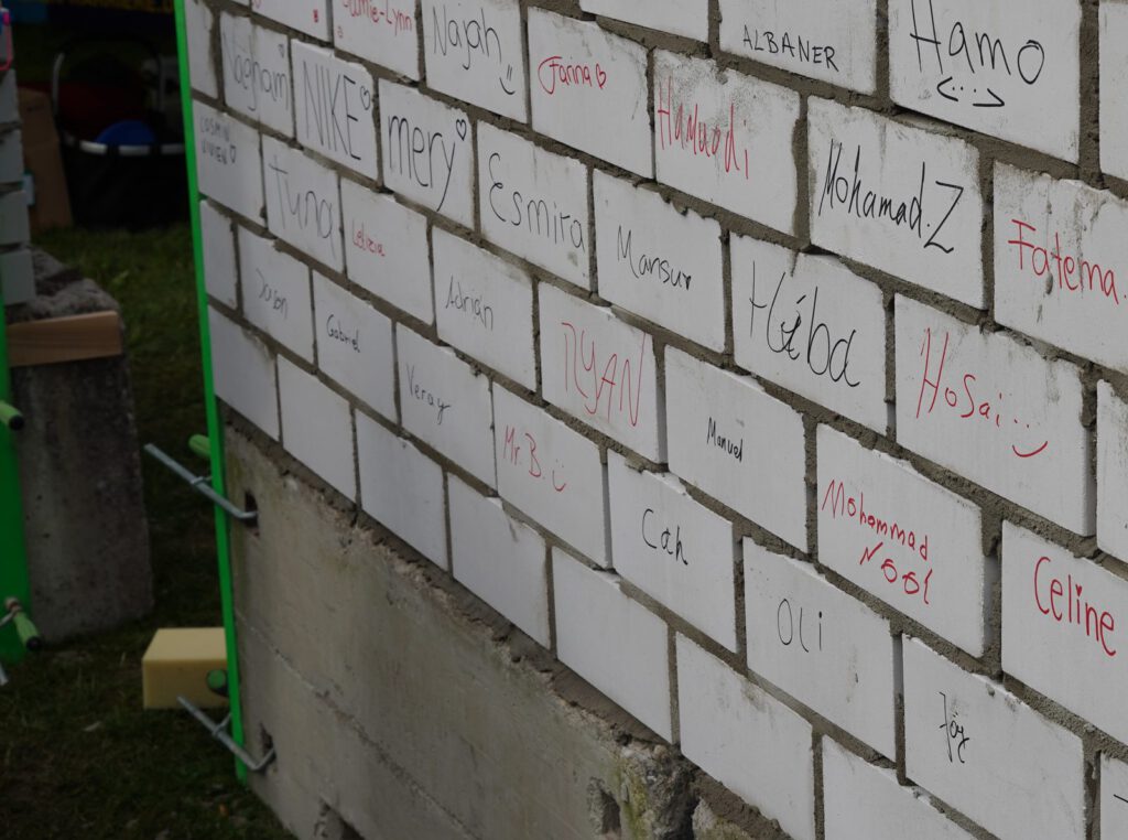 Mit Namen beschriftete Steine der gemeinsam gemauerten Wand
